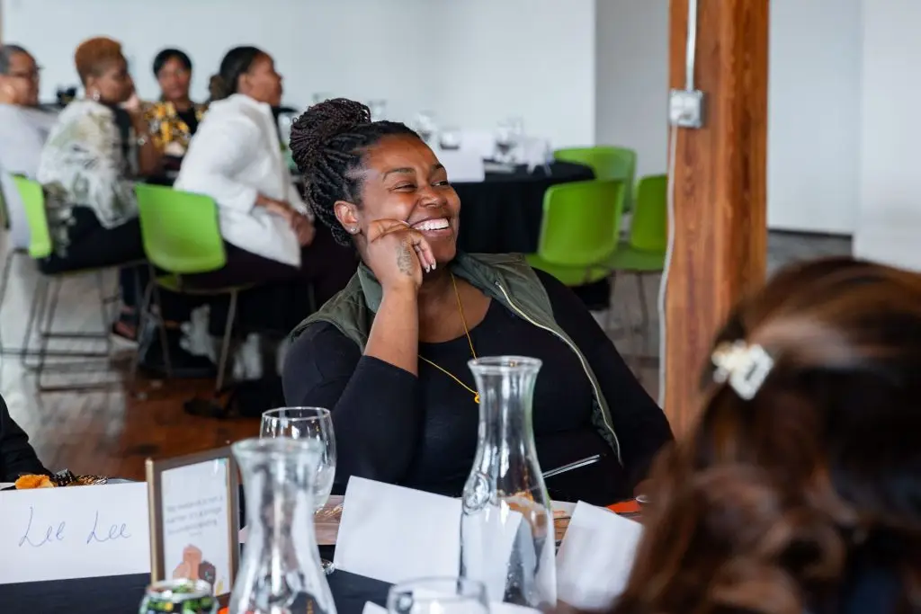a woman smiling at a table