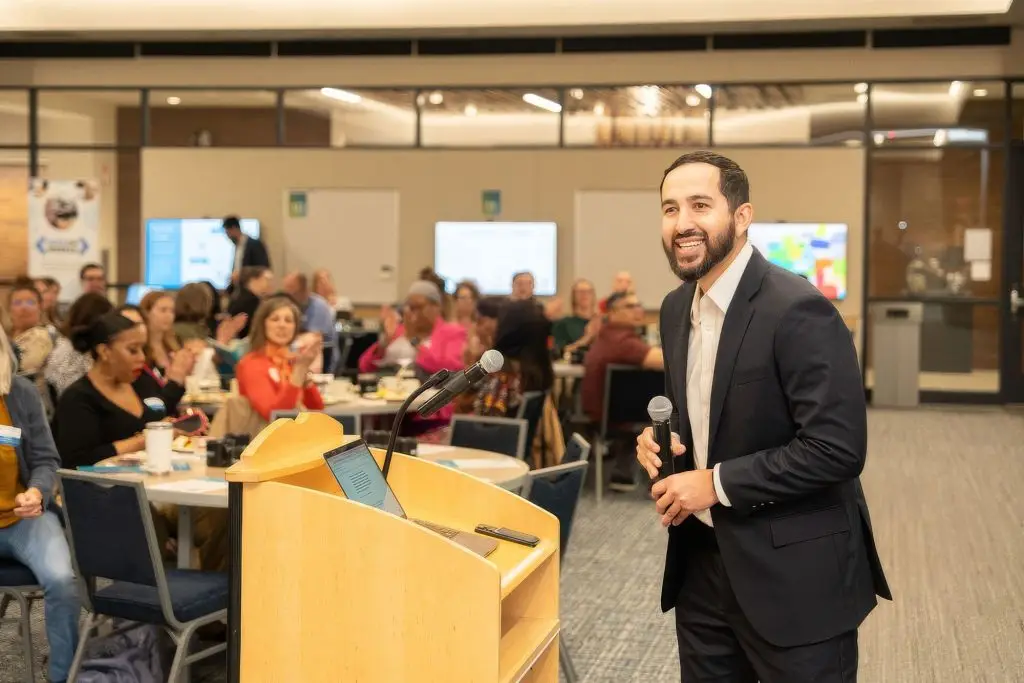Speaker presenting at nonprofit partnerships meeting with engaged audience of community stakeholders
