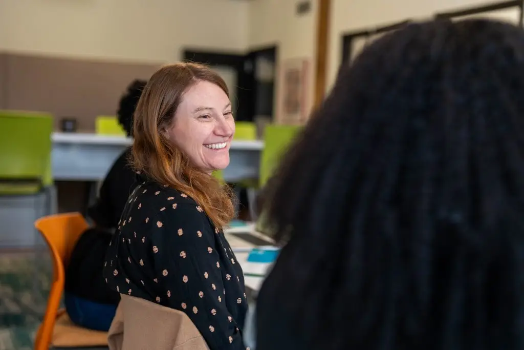 Lauren smiles at her colleague sitting to her right.